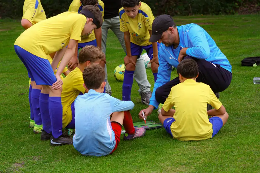 Het team verzamelt rond de coach tijdens een voetbalwedstrijd in Antwerpen