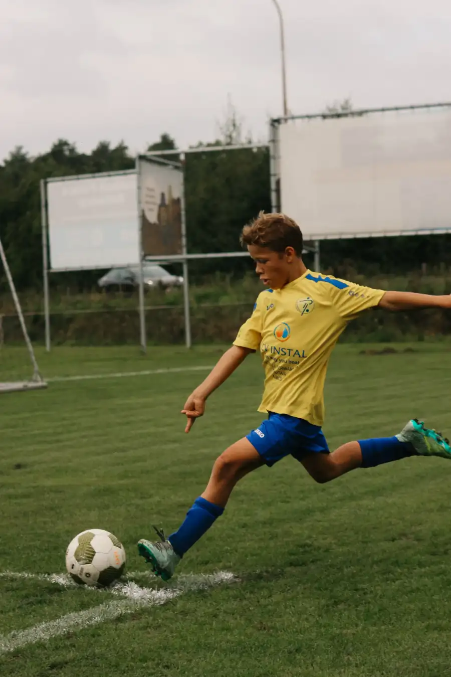 Voetballer in een geel shirt dribbelt met de bal — foto door Harun Viteskic voor Sideline Action